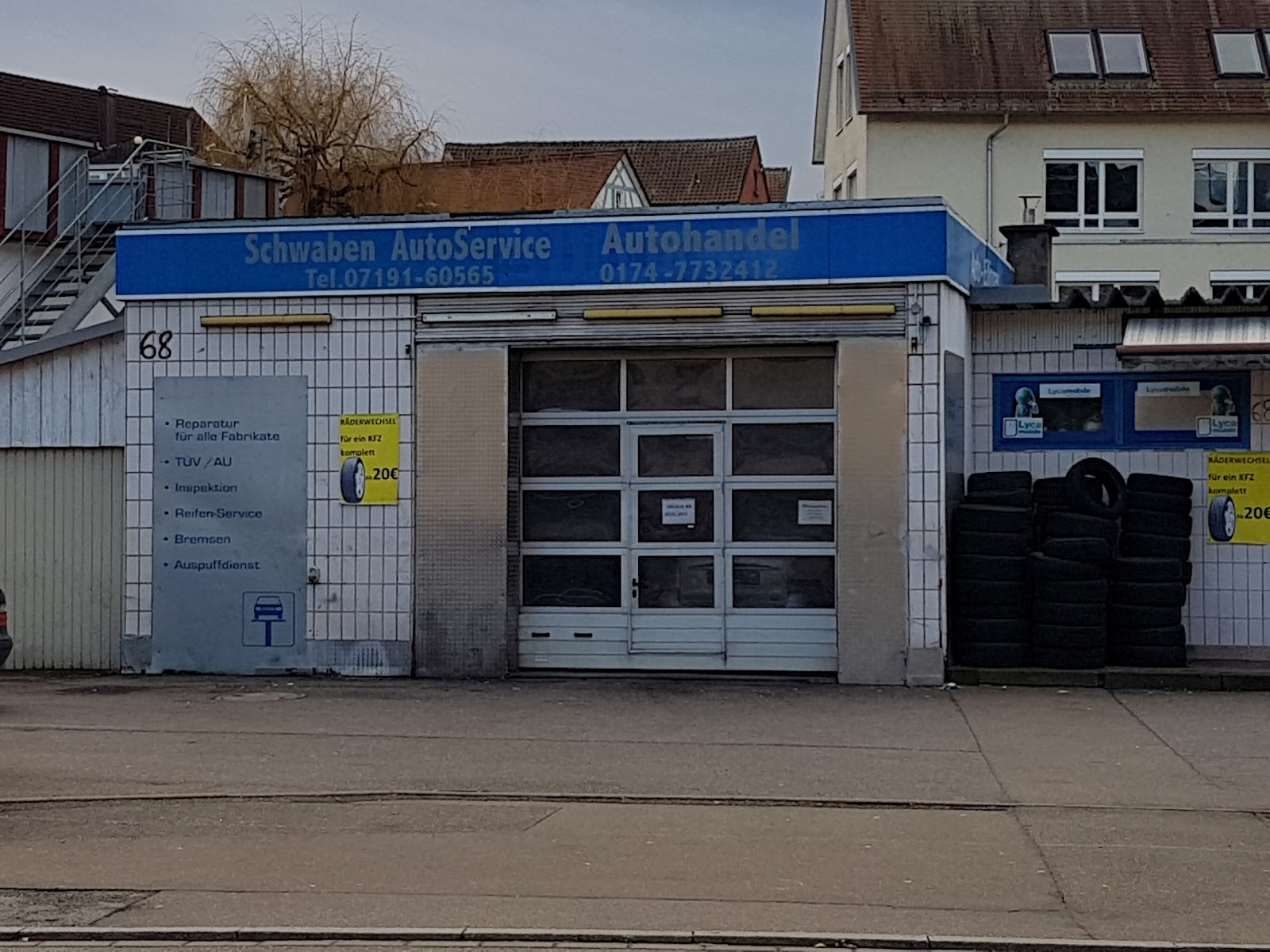 Fassade von Schwaben Autoservice Backnang mit Leistungsübersicht und Reifenstapel